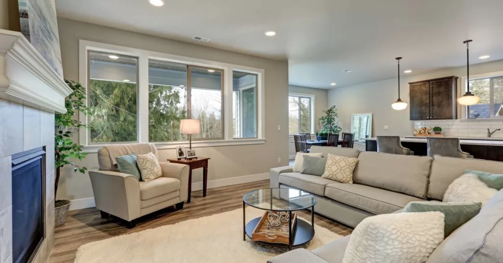 A living room with a view of the kitchen and dining room in the background. The living room features matching furniture.